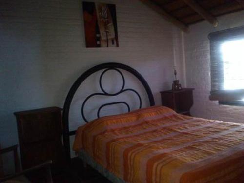 1 dormitorio con 1 cama con manta naranja en Cabañas Las Lunas, en La Pedrera