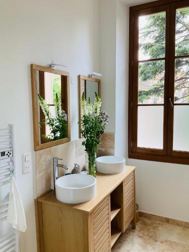 une salle de bain avec deux lavabos et deux miroirs dans l'établissement Grand appartement proche plages & centre ville, à Cannes