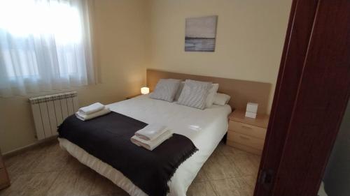 a bedroom with a large bed with towels on it at SANT BRIU in L'Escala