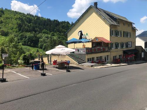 a building with a restaurant on the side of a street at Hôtel Les Mouflons in Le Mont-Dore