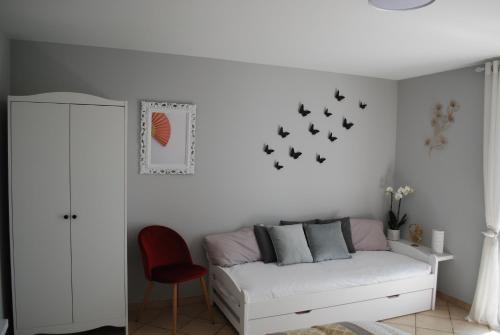 sala de estar con sofá blanco y pájaros en la pared en Résidence Bellevue en Pontacq
