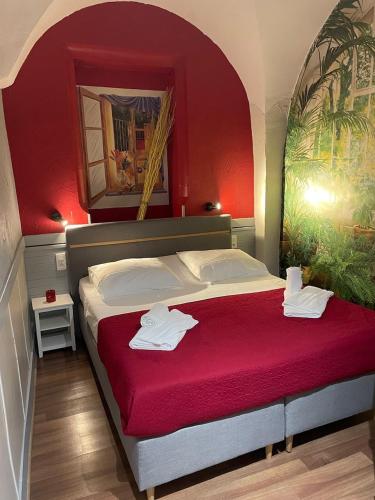 a bedroom with a large bed with red walls at Hotel de Savoie in Annecy