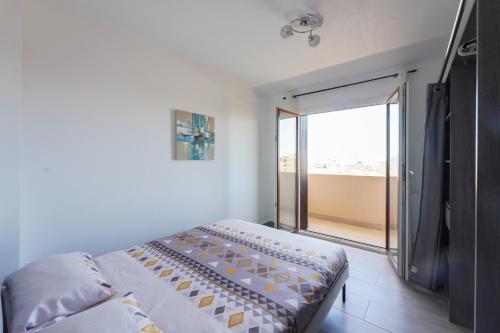 une chambre avec un lit et une grande fenêtre dans l'établissement T4 entièrement rénové proche plage, à Toulon