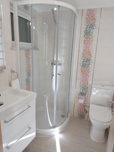 een witte badkamer met een douche en een toilet bij CASA BIA in Portimão