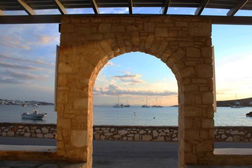 an archway with a view of the water and boats at Alkyon Hotel in Parikia
