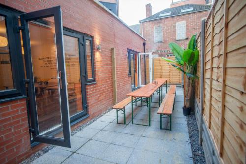 un patio con bancos, una mesa y un edificio en higgihaus #3a & 3b 8 Bed Sleeps up to 22 Big Groups Hip Location, en Bristol