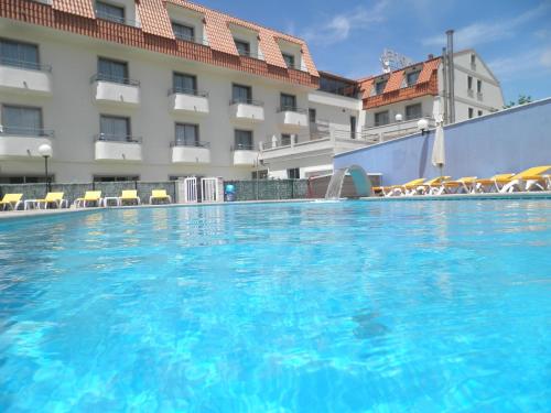 uma grande piscina em frente a um hotel em Hotel Campomar 3*** Superior em A Lanzada