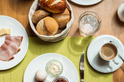 a table with plates of bread and a cup of coffee at B&B Hof Grosschreie in Hasle