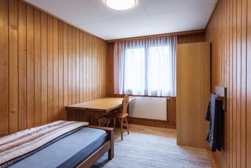 a bedroom with a bed and a desk and a window at B&B Hof Grosschreie in Hasle