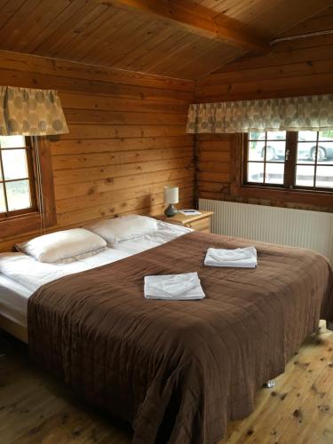 1 dormitorio con 1 cama grande y 2 toallas. en Heidi Cabin, en Reykholt