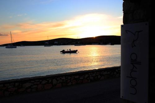 two people in a boat on the water at sunset at Alkyon Hotel in Parikia