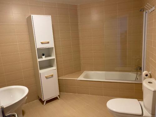 a bathroom with a tub and a toilet and a sink at Apartamento Aguamarina in Almerimar