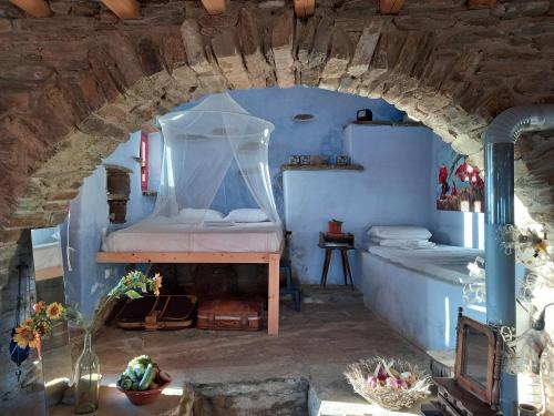a bedroom with a bed in a stone archway at Katerina's Sunset in Panormos