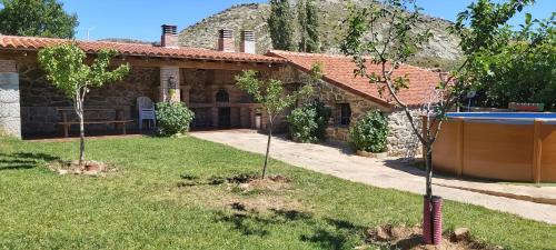 a house with a pool and two trees in the yard at CORRAL DEL PRAJONCILLO in Valdecasa