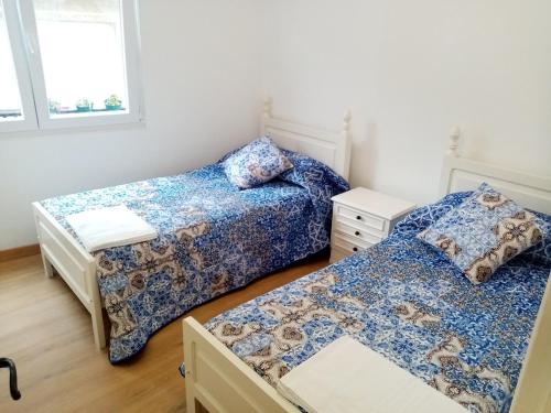 a bedroom with two beds and a window at Piso Muxía centro in Muxia