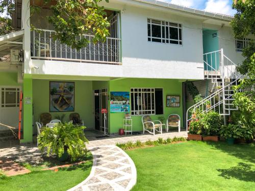 una casa con un verde y blanco en Posada Nativa Bernard Place, en San Andrés