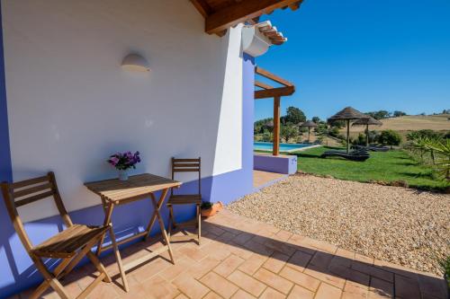 a patio with a table and chairs and a view of a yard at Ares do Monte - Turismo Rural in Cercal