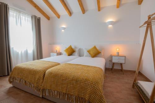 a bedroom with a large bed and a window at Ares do Monte - Turismo Rural in Cercal