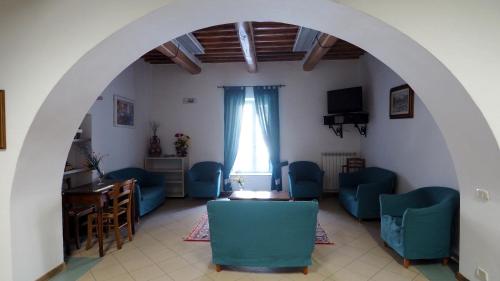 una stanza con sedie blu, tavolo e finestra di Residenza Pitigliano a Pitigliano