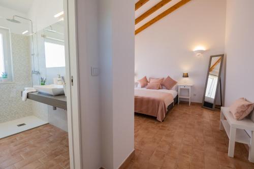 a bedroom with a bed and a bathroom at Ares do Monte - Turismo Rural in Cercal