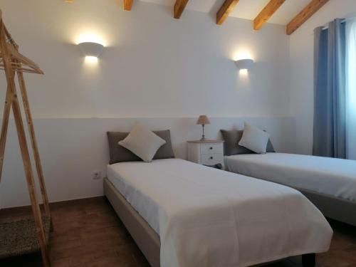 two beds in a room with white walls at Ares do Monte - Turismo Rural in Cercal