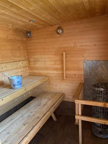 a wooden sauna with a bench and a bucket at Amber Terrace - Torrevieja in Torrevieja