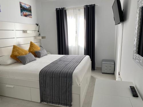 een slaapkamer met een bed en een televisie. bij White Suite Deluxe in Costa Teguise
