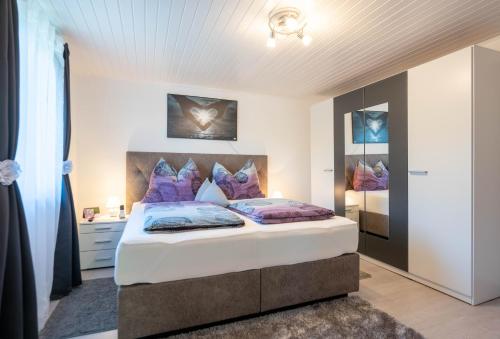 um quarto com uma cama grande e almofadas roxas em Ferienhaus Treissmann an der Weinstraße em Leutschach