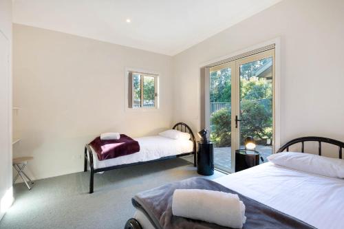 a bedroom with two beds and a window at Whale Cove Circuit in Eden