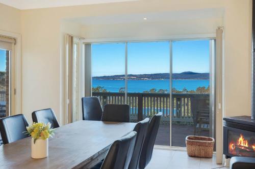 a dining room with a table and a fireplace at Whale Cove Circuit in Eden