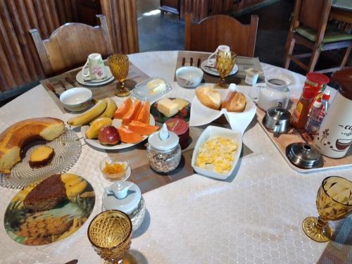 een tafel met daarop borden met eten bij Pousada Bosque Encantado in Bragança Paulista