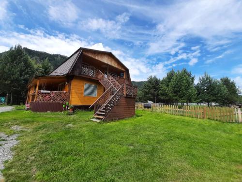 a log cabin with a staircase in a yard at Selskaya Usadba in Uznezya