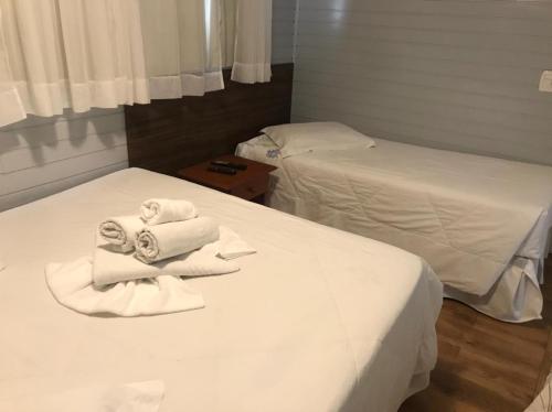 two beds in a room with towels on them at Apartamentos Sulla Collina Centro de Gramado localizado próximo da rua Coberta in Gramado