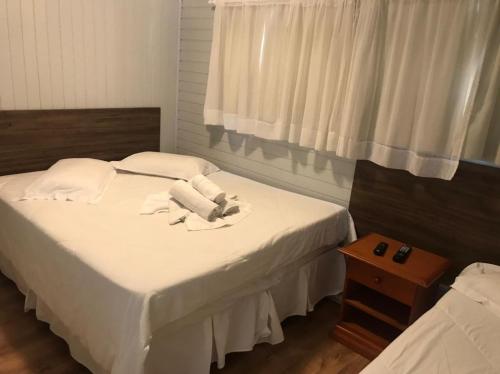 a bedroom with two beds with white sheets and a window at Apartamentos Sulla Collina Centro de Gramado localizado próximo da rua Coberta in Gramado