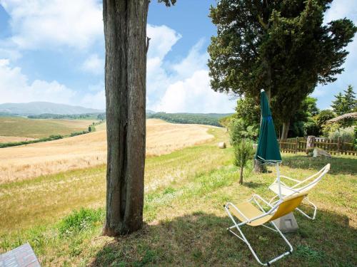a chair and an umbrella sitting next to a pole at Apartment in Collesalvetti near Pisa in Guasticce