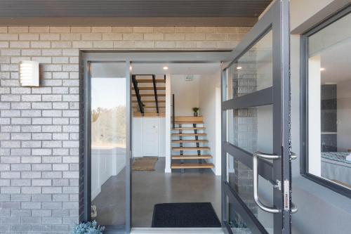 a glass door leading into a home with a staircase at Kingfisher Retreat @ Eden Cove in Eden