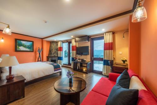 a hotel room with a bed and a red couch at Cat Cat Galerie d’Art in Sapa