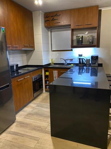 a kitchen with wooden cabinets and a black counter top at Valle Nevado Vip Apartment Ski Out-In in Valle Nevado