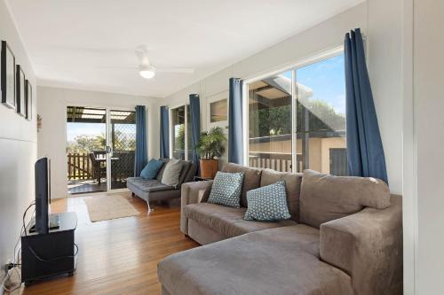 a living room with a couch and a tv at Bungo Beach house - Pet Friendly home in Eden