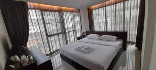 a bedroom with a bed with two towels on it at The Bangkok Airport Link Suite - SHA Plus in Bangkok
