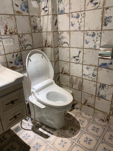 a bathroom with a toilet and a sink at 心享庭園民宿 Wishes B&B in Jian
