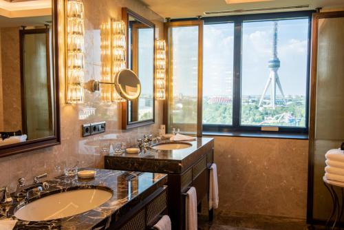 a bathroom with two sinks and a view of the eiffel tower at AZIMUT Grand Hotel Tashkent in Tashkent