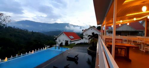 a house with a swimming pool with mountains in the background at The Fog Munnar (Resort & Spa) in Munnar