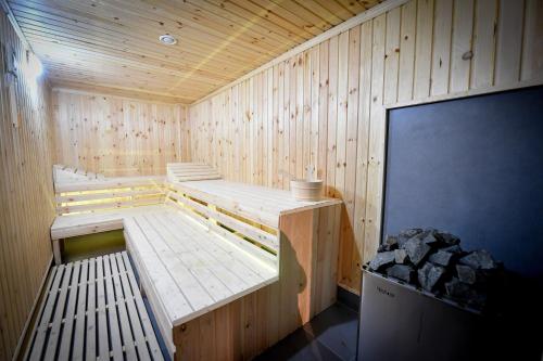 a wooden sauna with two benches and a tv at FRIENDS RESIDENCE Apartments in Timişoara