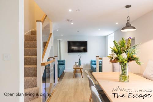 a dining room and living room with a vase of flowers on a table at The Escape; the ideal getaway on Brighton seafront in Brighton & Hove