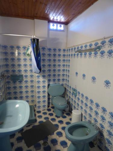 a bathroom with a blue toilet and a sink at GEORGES IPSOS APARTMENTS in Ipsos