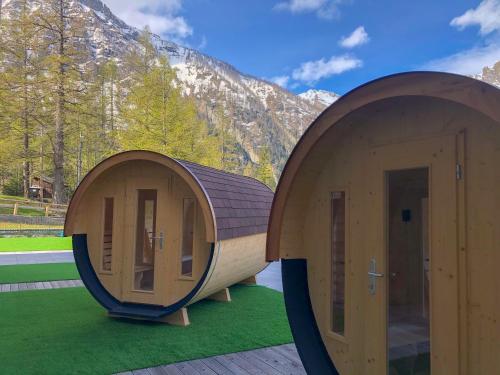 two circular wooden houses with a mountain in the background at Hotel La Vetta in San Domenico