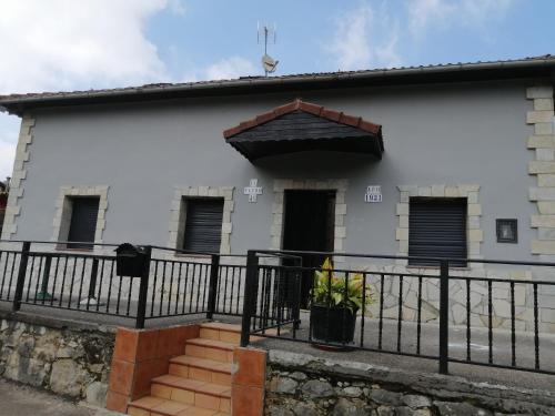 a white building with a black fence and stairs at Casa pando 49 in Pando