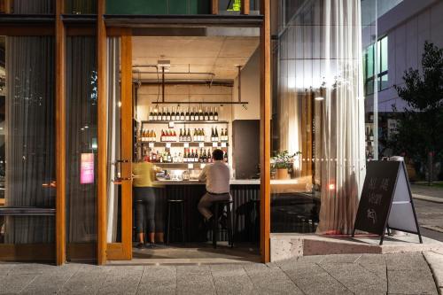 a man sitting at a bar in a building at Alex Hotel in Perth