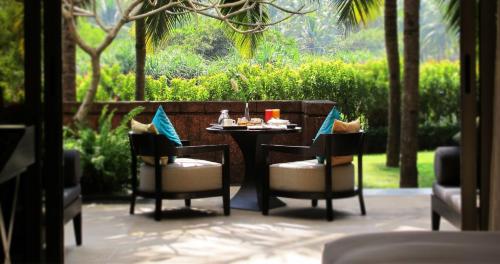 a table with two chairs and a table with food on it at Alila Diwa Goa - A Hyatt Brand in Majorda